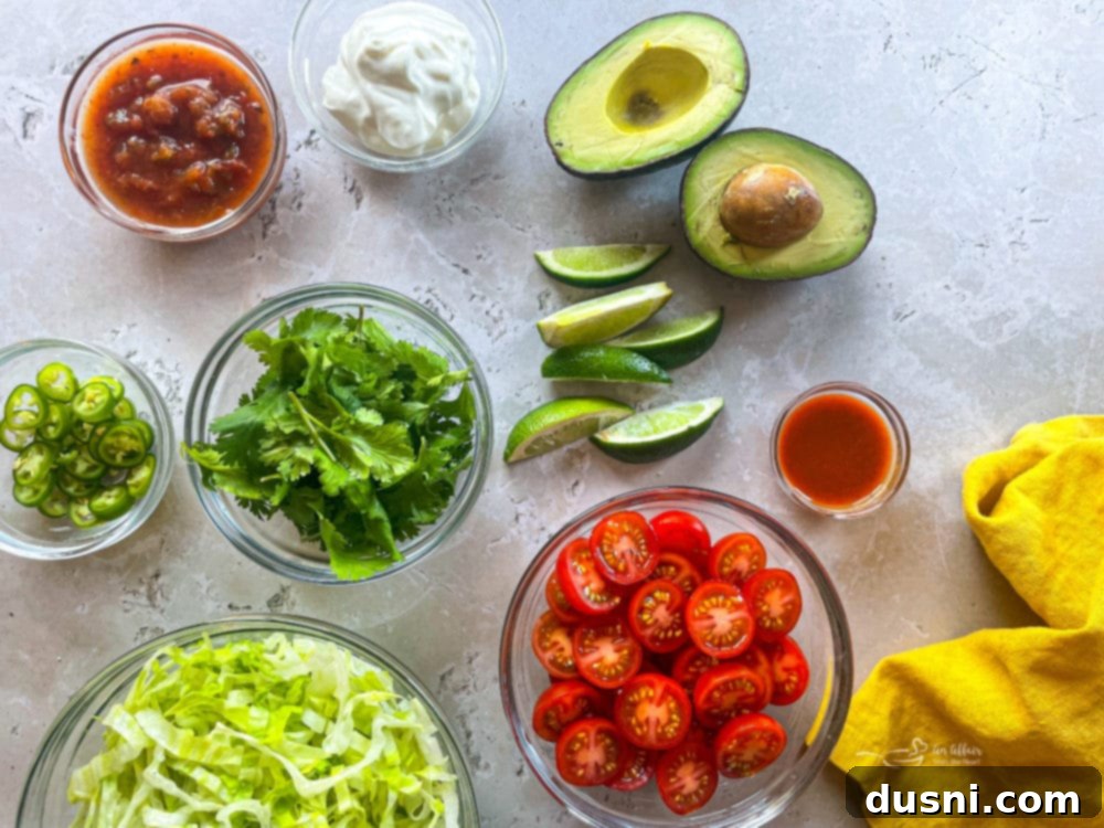 Variety of fresh taco toppings including lettuce, tomatoes, and avocado