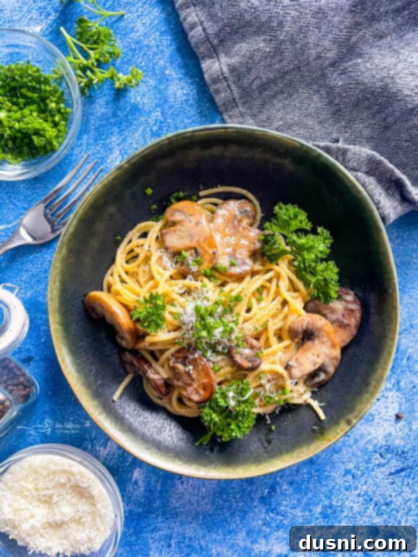 A beautifully presented bowl of Cacio e Pepe with mushrooms, garnished with fresh parsley, ready to eat.