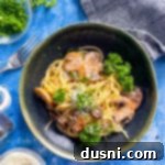 A single serving bowl of Cacio e Pepe pasta with mushrooms, garnished with fresh herbs.