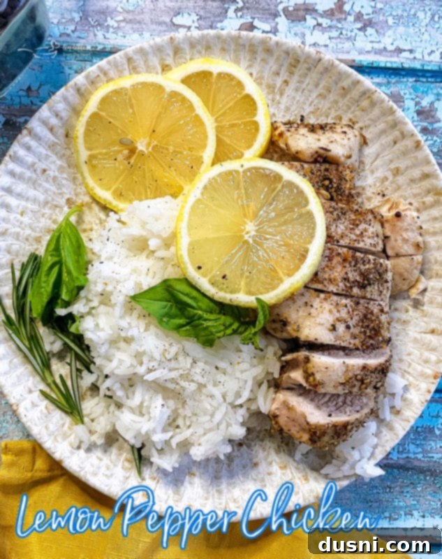 A hero shot of baked lemon pepper chicken with fresh lemons, ready to serve.