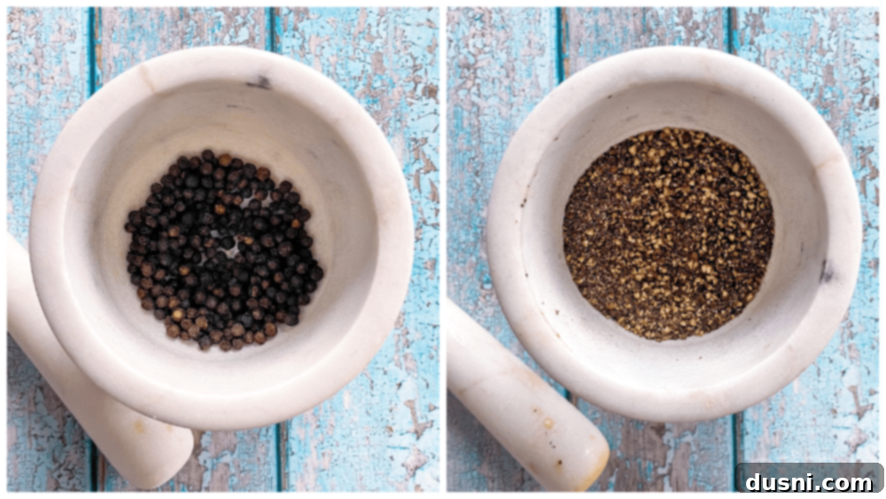 A close-up of a hand grinding fresh black peppercorns, illustrating the preparation of homemade lemon pepper seasoning.
