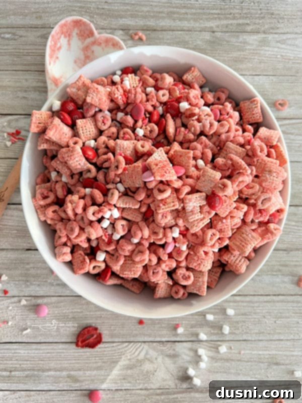 Pink Puppy Chow A white bowl filled with finished strawberry Chex Mix.
