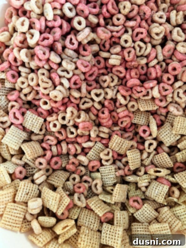 Strawberry White Chocolate Cereal Crunch 5 Mixing two types of cereal for strawberry Chex Mix.