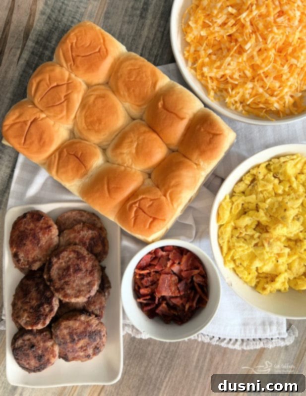 Sunrise Sliders 8 Assortment of fresh ingredients for breakfast sliders: Hawaiian rolls, shredded cheese, scrambled eggs, cooked bacon, and sausage patties.