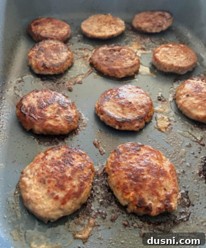 Sunrise Sliders 9 Pork sausage patties cooking on a hot griddle until nicely browned.