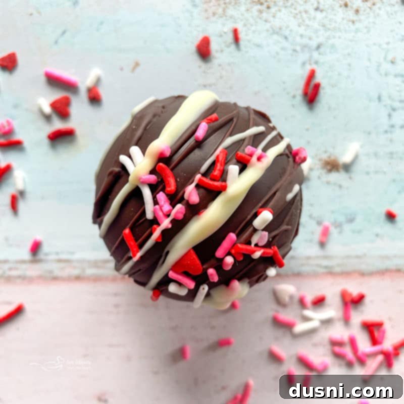 white chocolate drizzled and candy sprinkled hot chocolate bomb