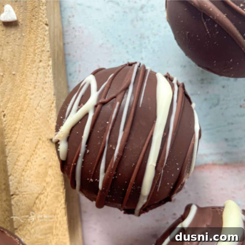 hot cocoa bomb drizzled with white chocolate