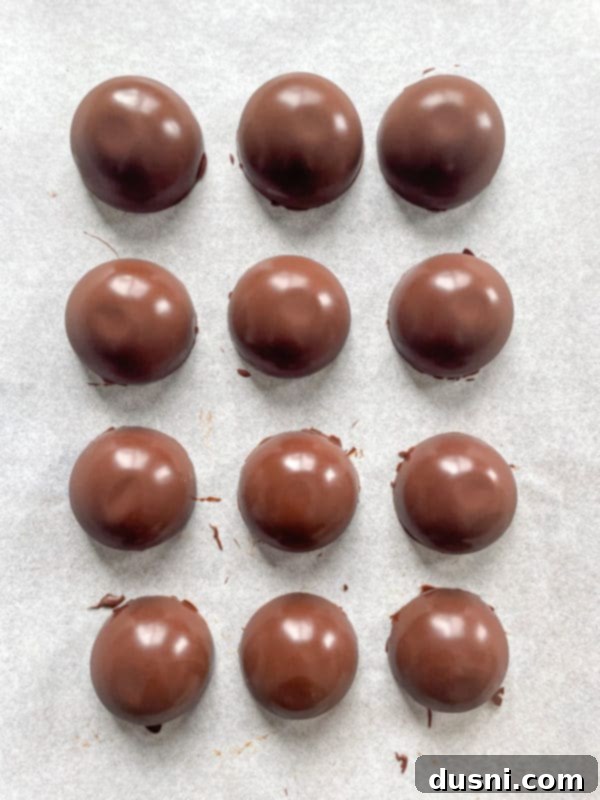 hot cocoa bombs on a parchment ready for the freezer