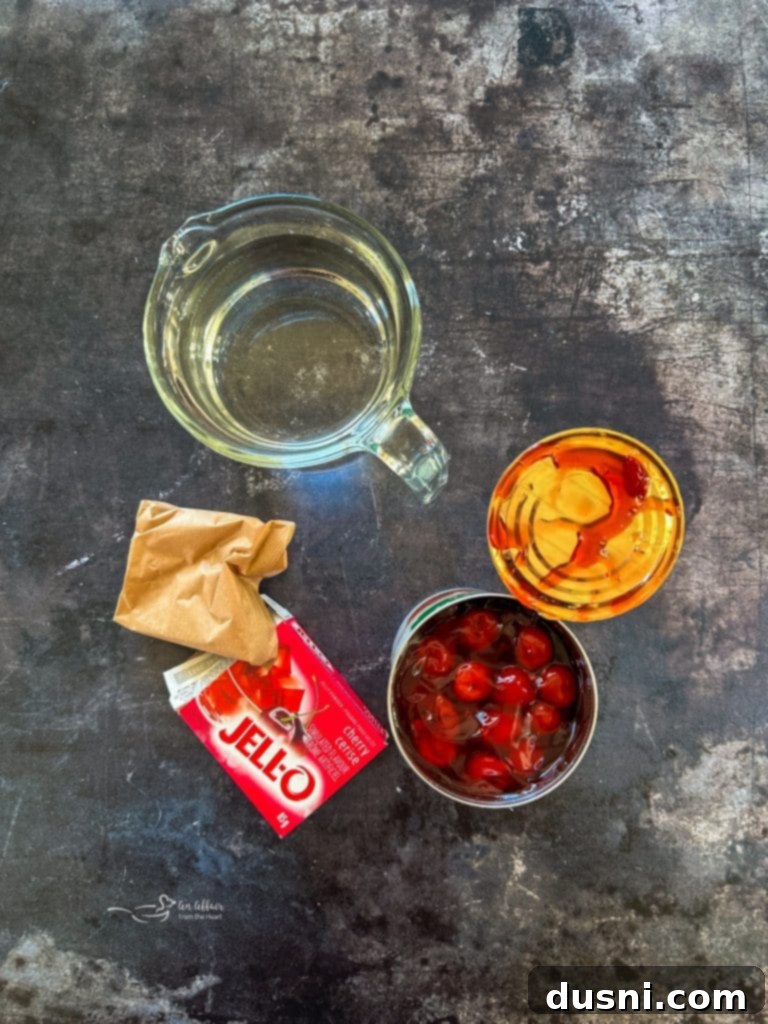 Holiday Cherry Pie Bliss 4 A festive red Cherry Pie Jell-O Salad in a clear glass bowl, showcasing its beautiful color and texture.