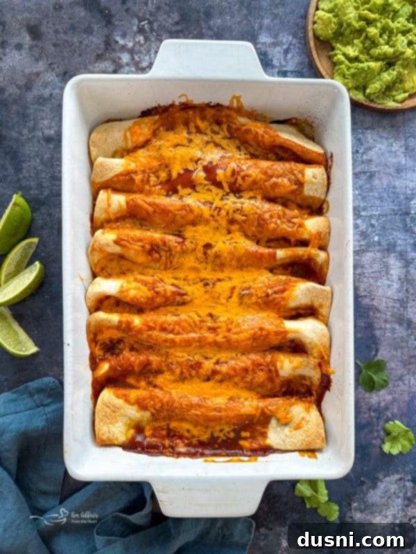 Quick & Easy Ground Beef Enchiladas 9 Step-by-step image: Assembled enchiladas in a baking dish, topped with more sauce and cheese before baking.