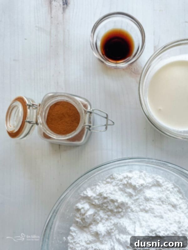 Ingredients for King Cake donuts, including flour, sugar, eggs, buttermilk, and cinnamon, laid out with measuring cups.