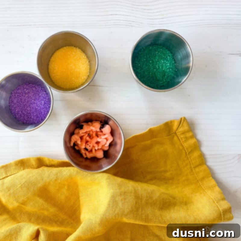 Multiple glazed King Cake donuts, some decorated with colorful sugar, sitting on a wire cooling rack.