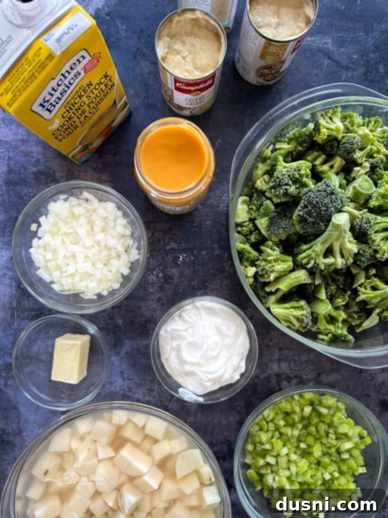 Overhead shot of a white bowl filled with creamy broccoli cheese soup, garnished with parsley and served with crusty bread.