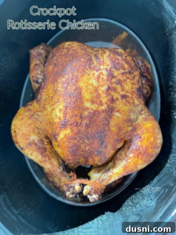 Cooked Slow Cooker Rotisserie Chicken resting on a cutting board