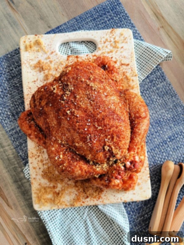 Hands rubbing seasoning mix onto a whole raw chicken