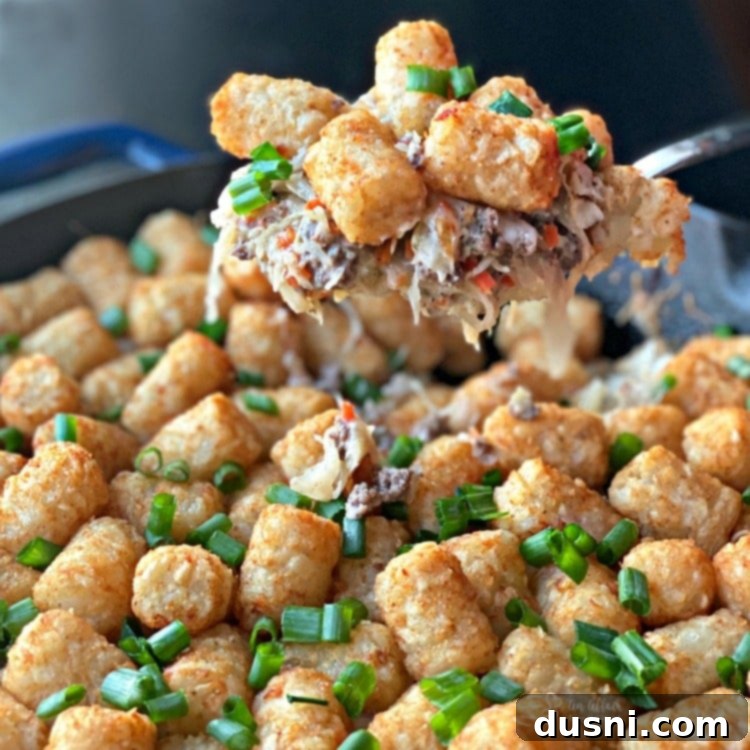 A spoonful of Beef & Kraut Tater Tot Casserole, showing the hearty layers of beef, sauerkraut, and crispy tater tots.