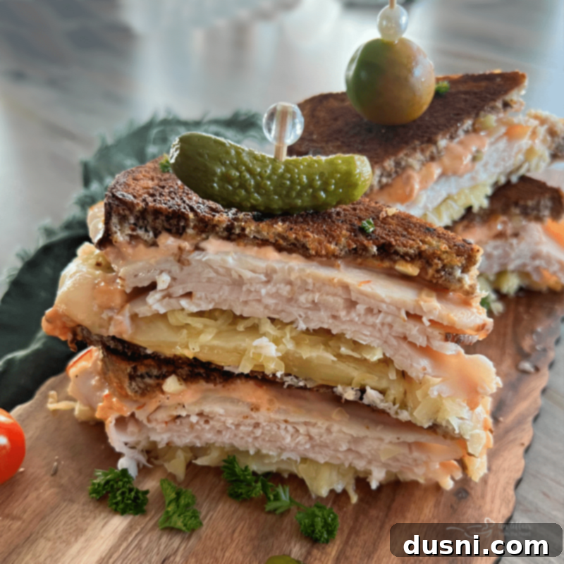 Two perfectly assembled Turkey Reuben (Rachel) sandwiches, ready to be grilled, showing the layers of ingredients.