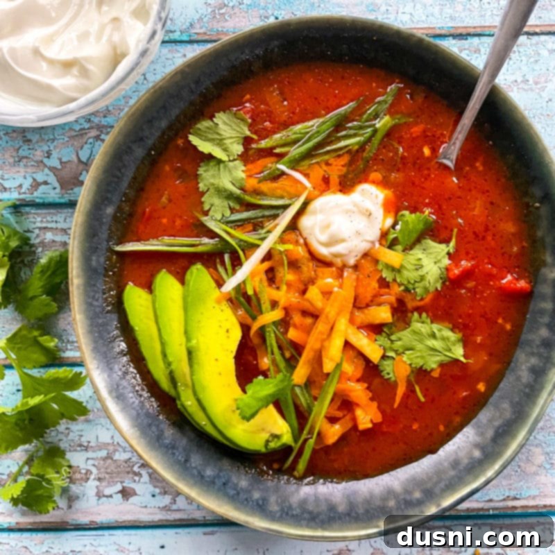 A ceramic bowl filled with steaming tortilla soup, ready to be enjoyed as a hearty meal.