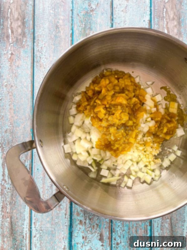 Onions, green chilies, and garlic sizzling in a pan, releasing their aromatic flavors for the tortilla soup base.