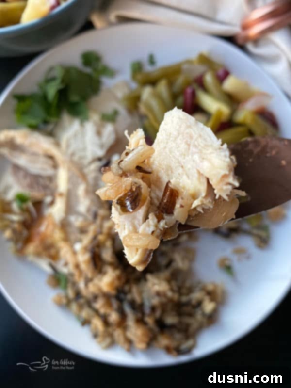 Effortless Wild Rice Stuffed Chicken 3 Close-up of baked whole chicken, golden brown and glistening, with wild rice stuffing visible.