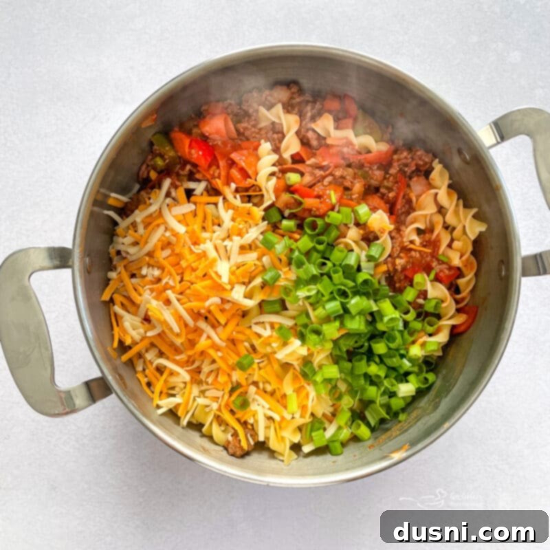 Pepperoni added to the ground beef mixture in a skillet