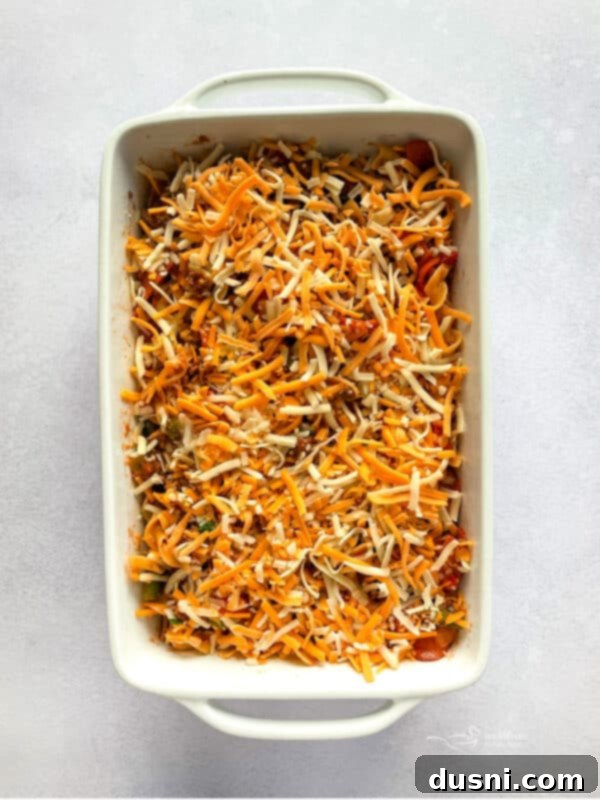 Mixing pasta, sauce, and cheese in a skillet for pizza pasta