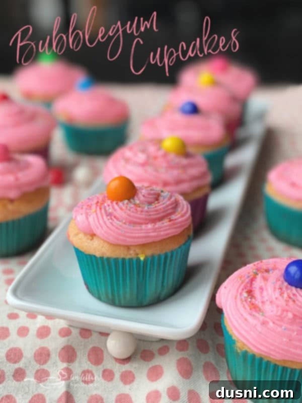 Two hands holding a bubblegum cupcake