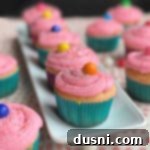 Bubblegum cupcakes on a white platter and on a table