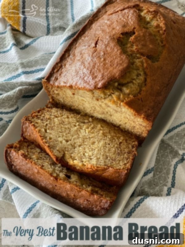 The Ultimate Banana Bread 7 A perfectly baked slice of banana bread with a golden crust and moist interior, served with coffee