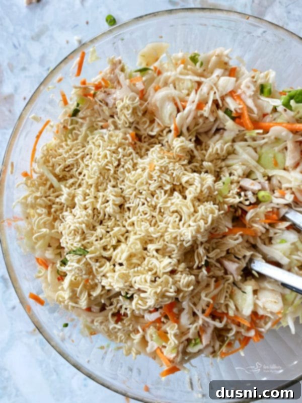 Adding and mixing ingredients for Asian Chicken Salad