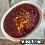 Mom's Homemade Cranberry Perfection 12 Overhead shot of Mom's Homemade Cranberry Sauce in a white serving dish, garnished and ready to serve.