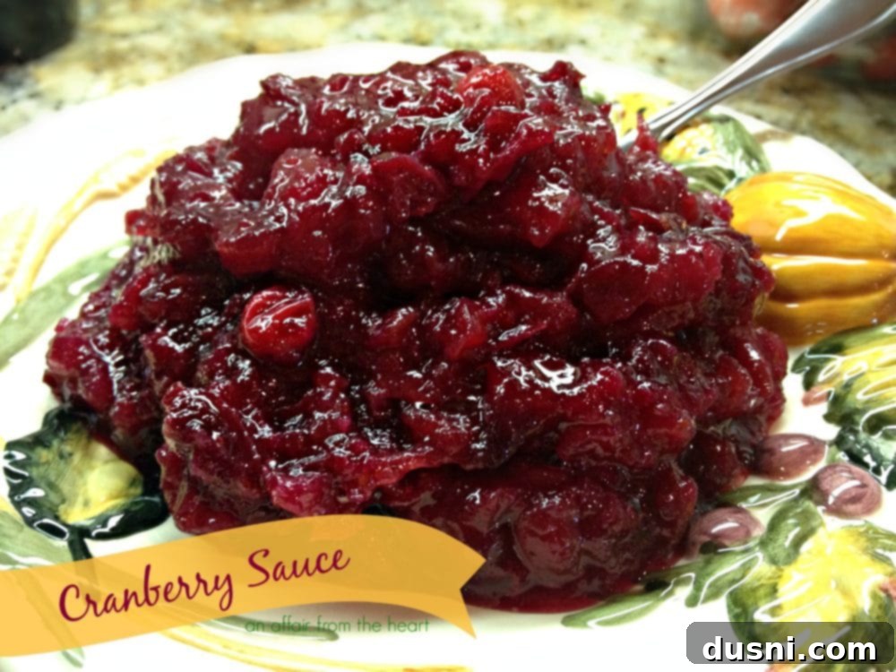 Mom's Homemade Cranberry Perfection 3 A close-up shot of vibrant red cranberries simmering in a saucepan with orange slices, indicating the start of homemade cranberry sauce.