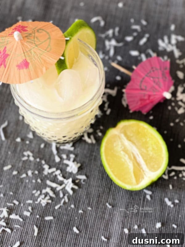 Two glasses of creamy Brazilian Lemonade cocktails, garnished with fresh lime slices, ready to be enjoyed.