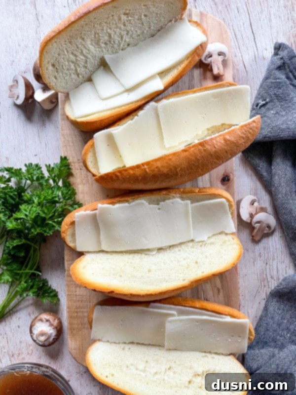 Mouthwatering Crock Pot French Dip Sandwiches 10 Hoagie buns topped with melted provolone cheese, ready for the beef.