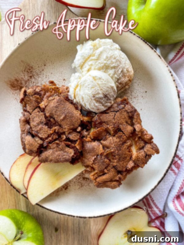 A complete fresh apple cake served in a white bowl, accompanied by ice cream and additional sliced fresh apples, showcasing a beautiful presentation.