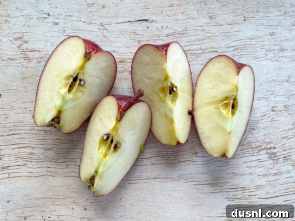A selection of fresh, crisp apples resting on a rustic wooden cutting board, ready for preparation.