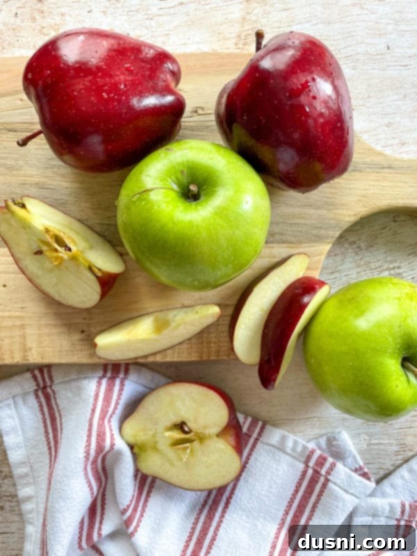 A vibrant assortment of green and red apples displayed on a wooden cutting board, highlighting the freshness of the key ingredient.