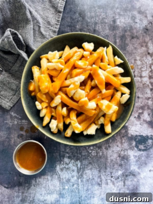Authentic Homemade Poutine: A Canadian Classic 3 Overhead View of Poutine with Gravy on Side