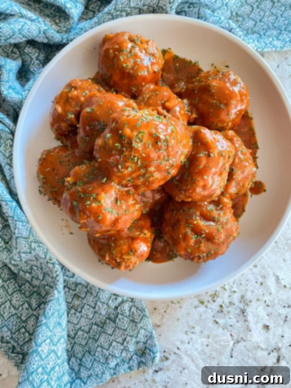Savory Rice-Studded Meatballs 2 Porcupine Meatballs in a skillet with rich tomato sauce