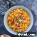 Coastal Crab & Shrimp Pasta 14 A white bowl of Crab & Shrimp Pasta with shredded cheese on top.