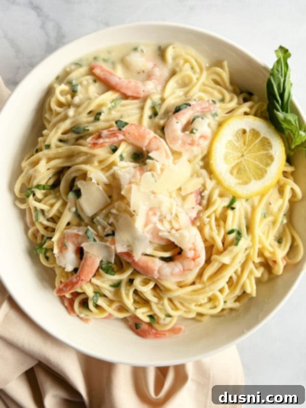 Bright Lemon Basil Creamy Shrimp Pasta 2 Shrimp Pasta in a Bowl with Lemon Slices and Basil