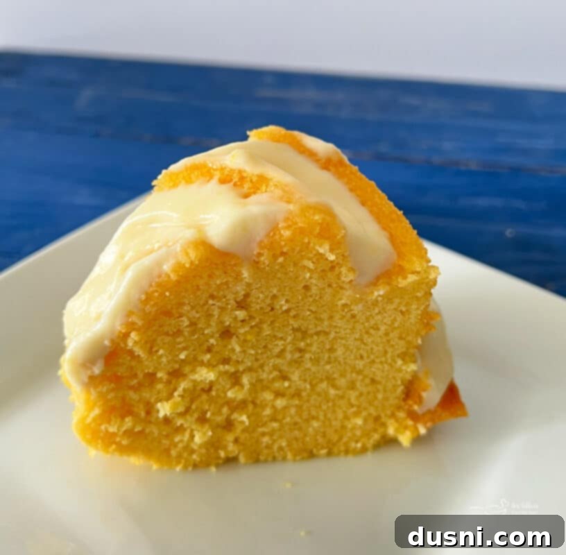 Luscious Lemon Cream Cheese Bundt Cake 7 A beautifully frosted lemon cake with cream cheese frosting on a plate, ready to be served.