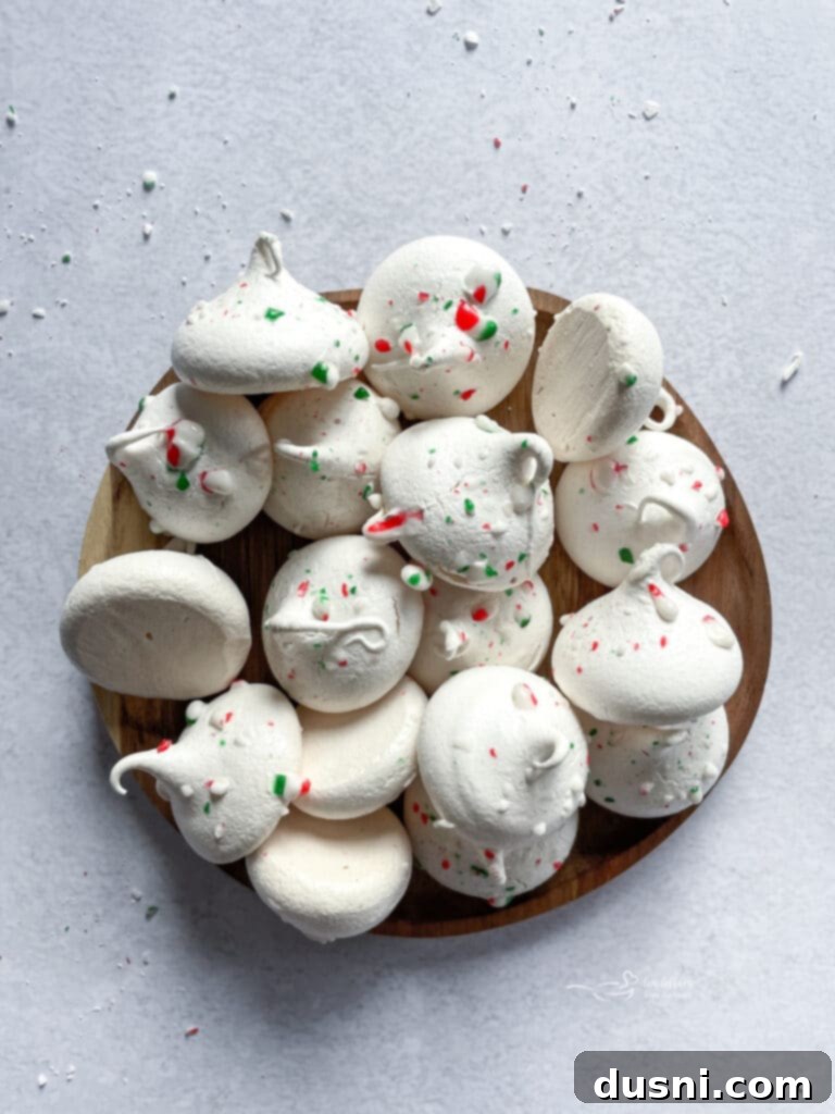 Delicate Peppermint Meringues presented in a rustic wooden serving dish.