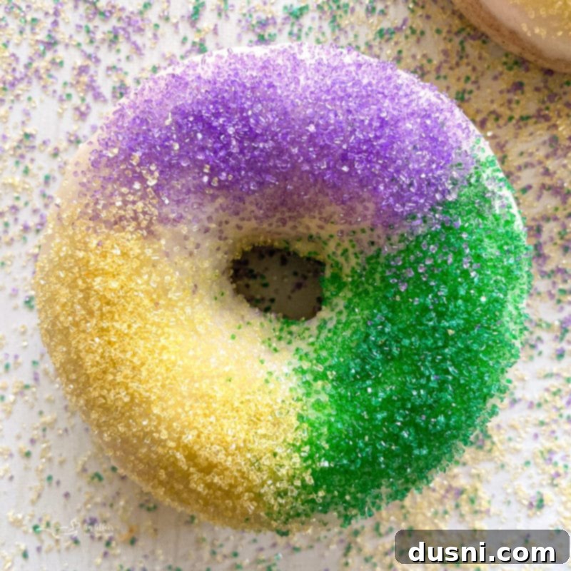 square image of one king cake donut with icing and sprinkles
