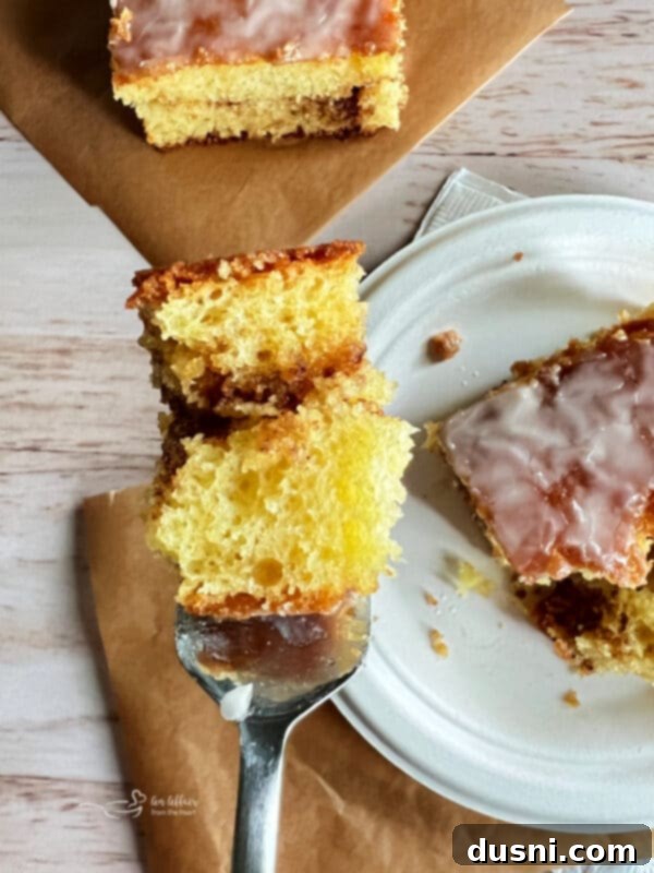 Close-up of a bite of Honey Bun Cake on a Fork, showing the moist cake and glaze