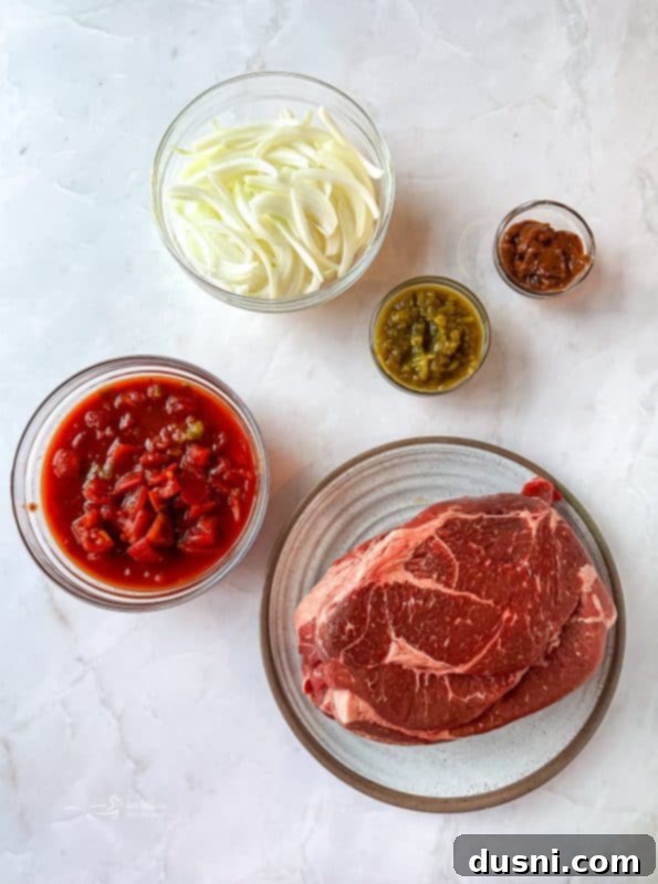 Tender Slow Cooker Pulled Beef Burritos 5 Several shredded beef burritos stacked on a white plate with fresh ingredients like avocado and lime.