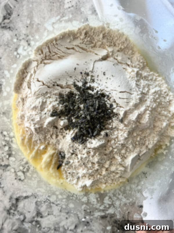 Lavender Shortbread and Lavender Strawberry Cream 12 Flour and dried lavender buds being added to the creamed butter and sugar mixture in a stand mixer.