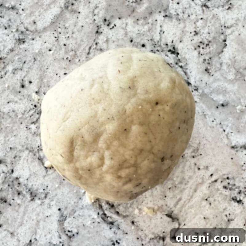 Lavender Shortbread and Lavender Strawberry Cream 13 Shortbread dough being kneaded by hand on a lightly floured surface, showing its crumbly texture.