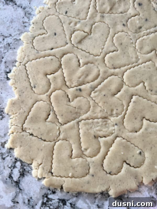 Lavender Shortbread and Lavender Strawberry Cream 14 Shortbread dough being rolled flat with a rolling pin on parchment paper.