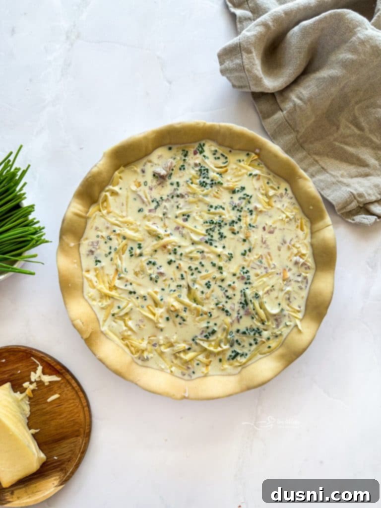 Savory Ham and Smoked Gouda Quiche 9 The egg and half & half mixture being poured over the layered ingredients.